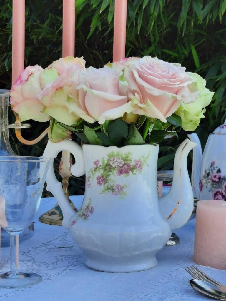 théière transformée en vase avec des roses pour déco de mariage