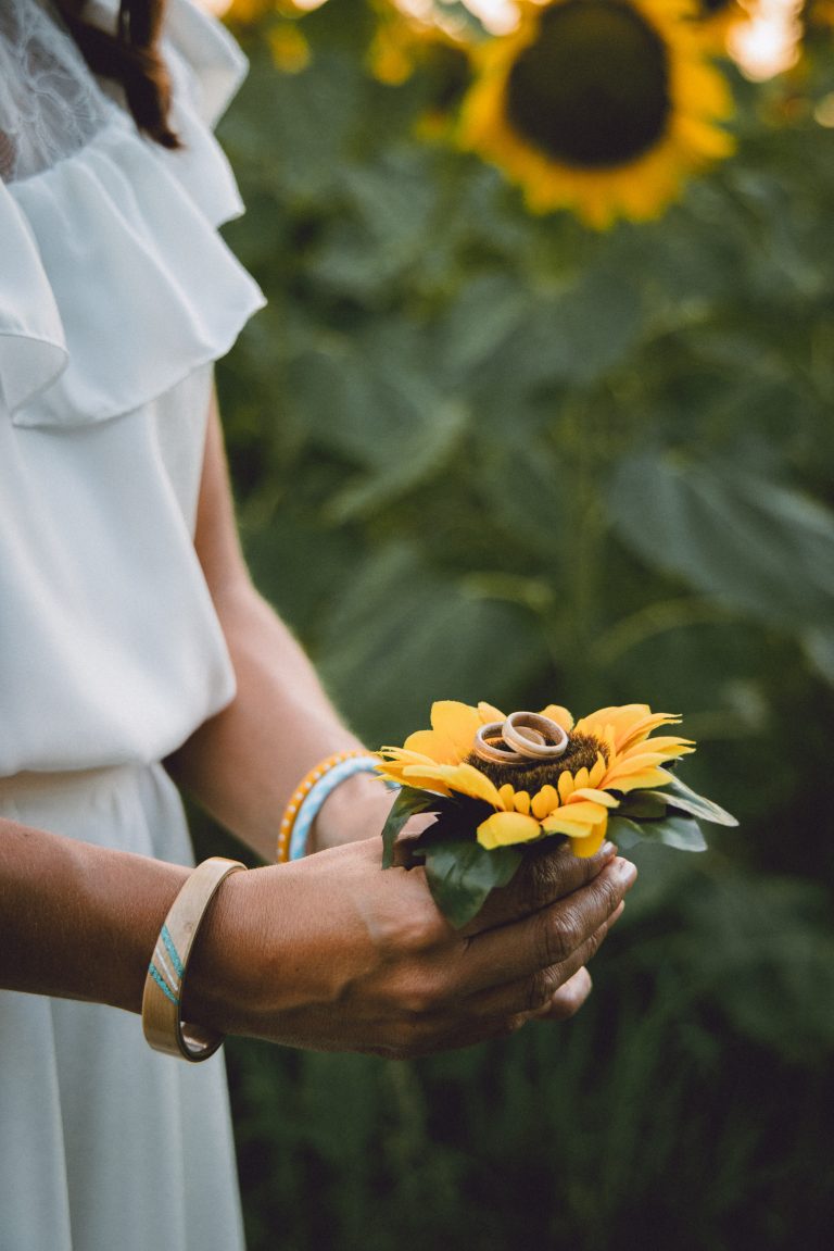 Anneaux de mariage reposant délicatement sur un tournesol vibrant.