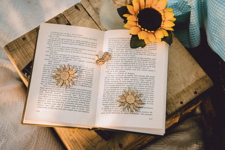 Livre ouvert avec des tournesols et marque-pages en forme de fleur.