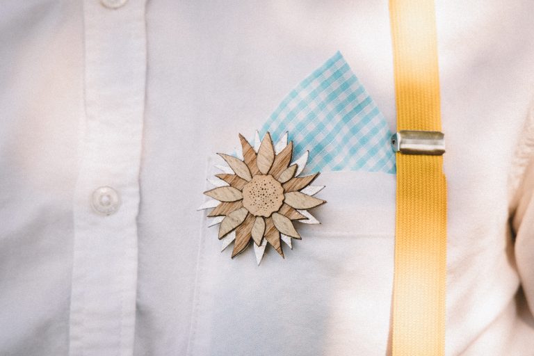 Boutonnière de tournesol sur chemise blanche avec ruban jaune.