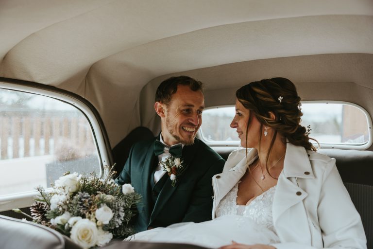 Mariés souriants dans une voiture vintage lors d'un shooting d'inspiration mariage