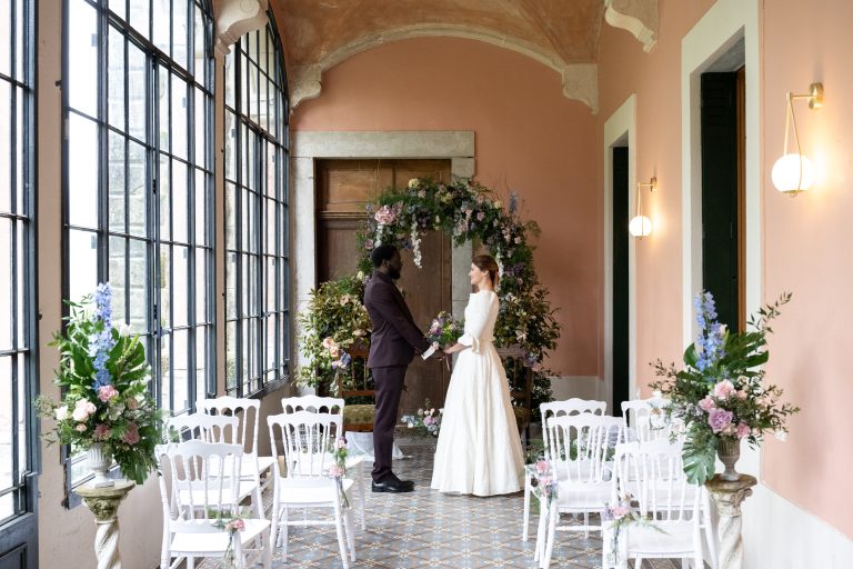 Mariés se tenant la main sous un arché floral, mariage style Bridgerton