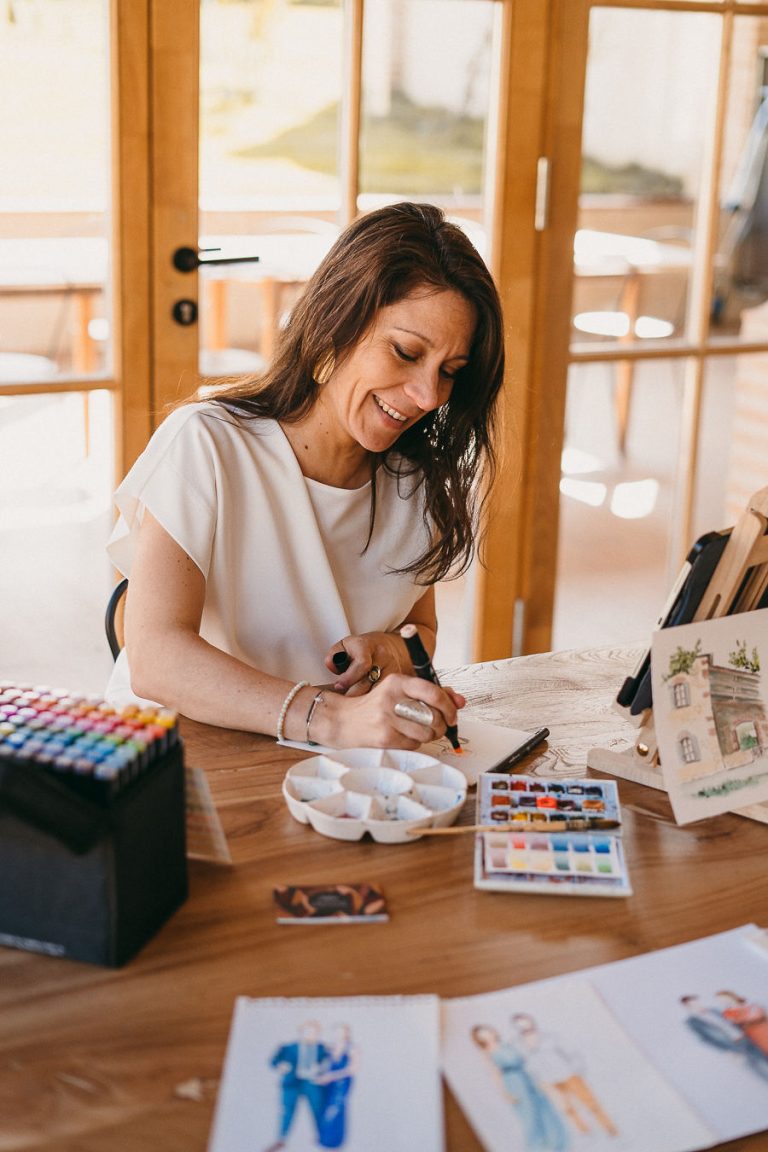 Artiste en train de peindre une aquarelle sur une table en bois