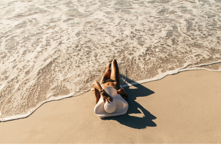 Une femme en bikini se relaxant au soleil sur la plage