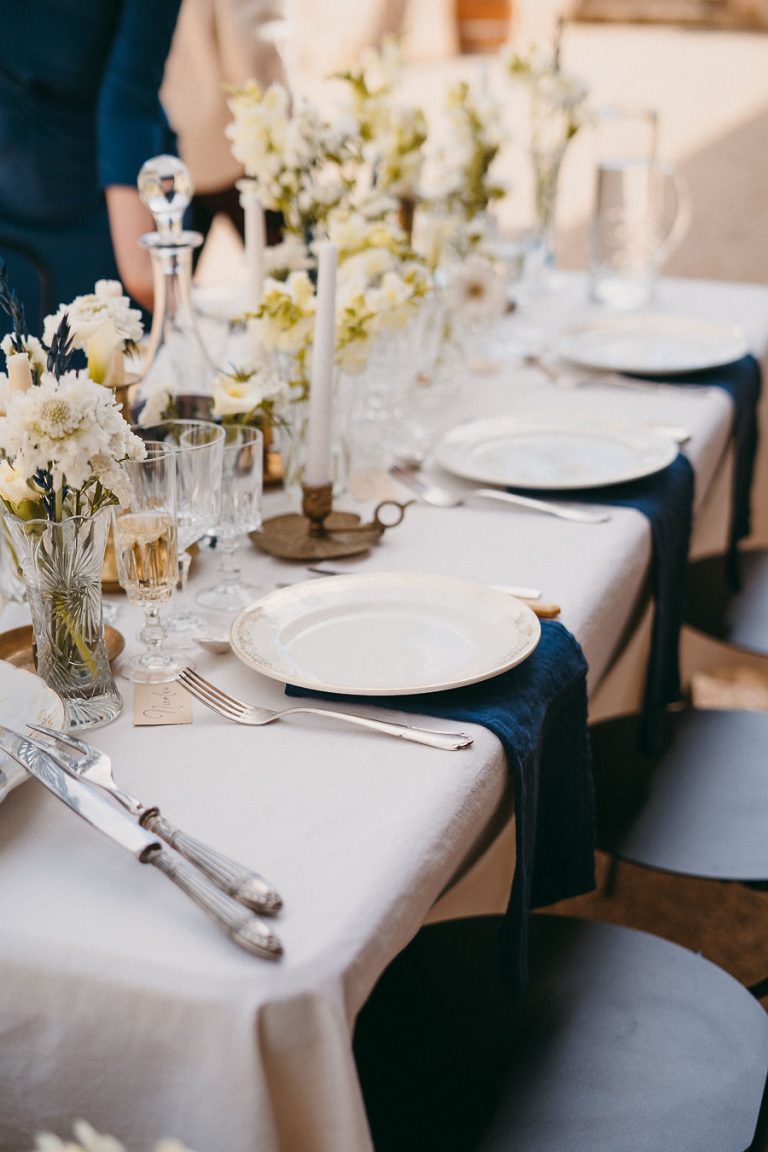 Table de réception avec une vaisselle élégante et des fleurs blanches