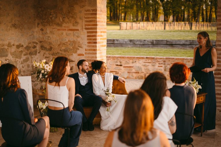 Les mariés et leurs invités rient ensemble pendant une discussion détendue post-cérémonie.