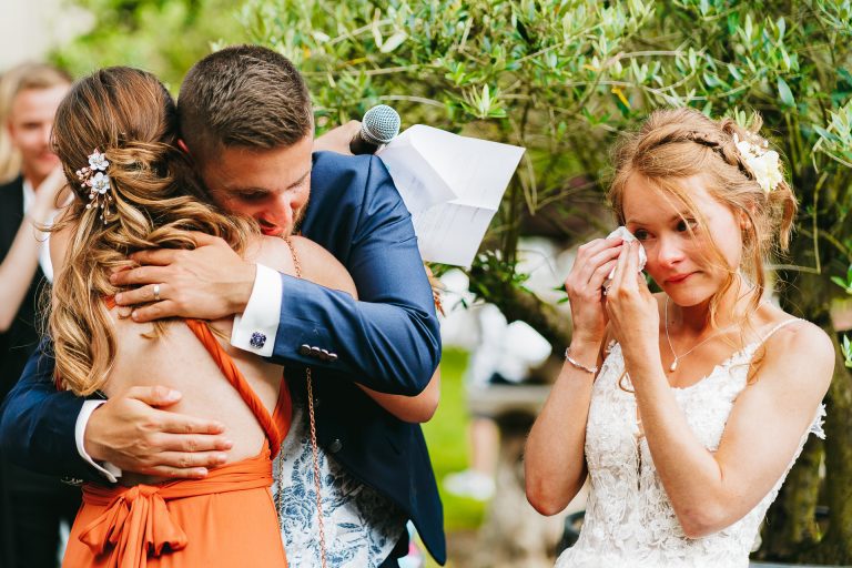 Moment d’émotion capturé entre une mariée et ses proches, larmes et câlins.